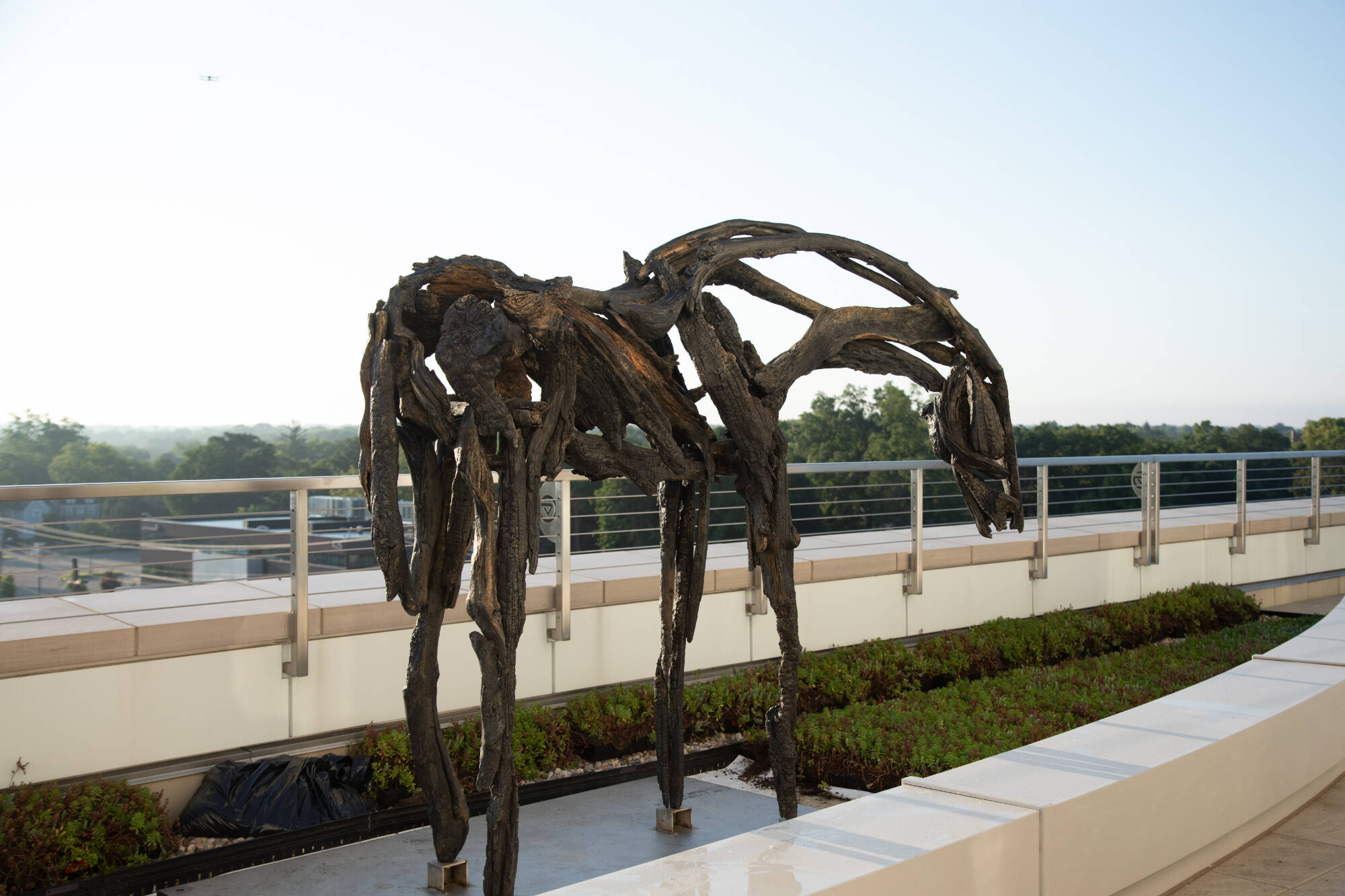 Bronze sculpture that looks like a horse made out of burnt sticks and rubble.